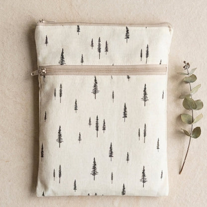 Waterproof double zipper cotton fabric pouch with tree pattern on a red background. Beige and cream. on a stone background and eucalyptus on the side.