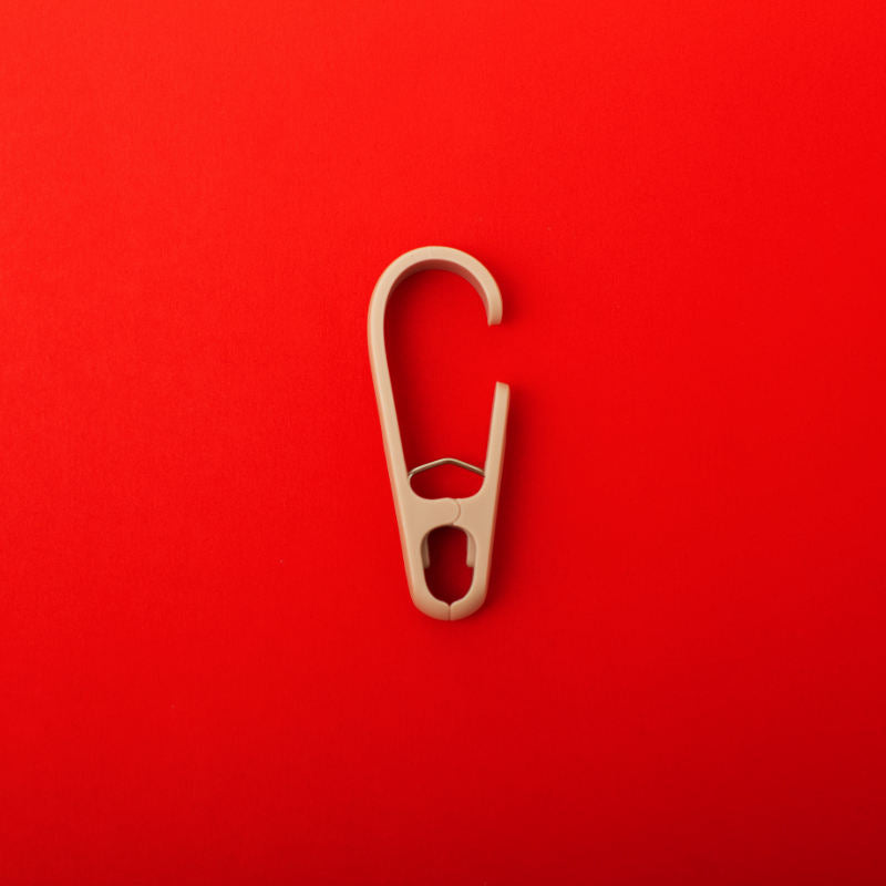 single clothing clip hook on a red background