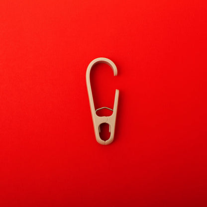 single clothing clip hook on a red background