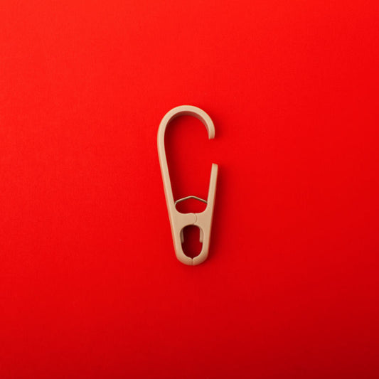 single clothing clip hook on a red background