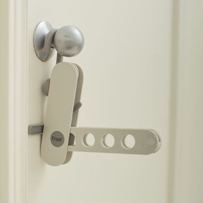 A white and grey hanger rack on a silver metal door handle on a white door