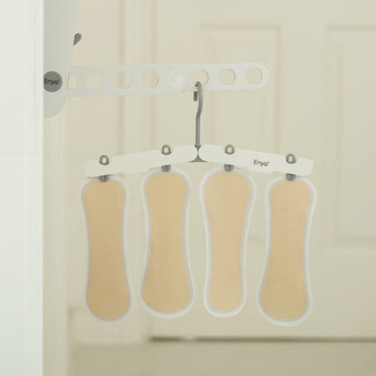 How do you care for The Stay Liner? Four reusable panty liners hang on a white drying rack, showcasing their lightweight and breathable design for easy washing and fast drying.