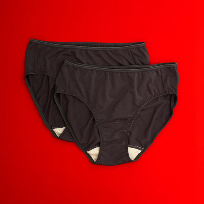 Two pairs of black underwear with wide white gusset on a red background