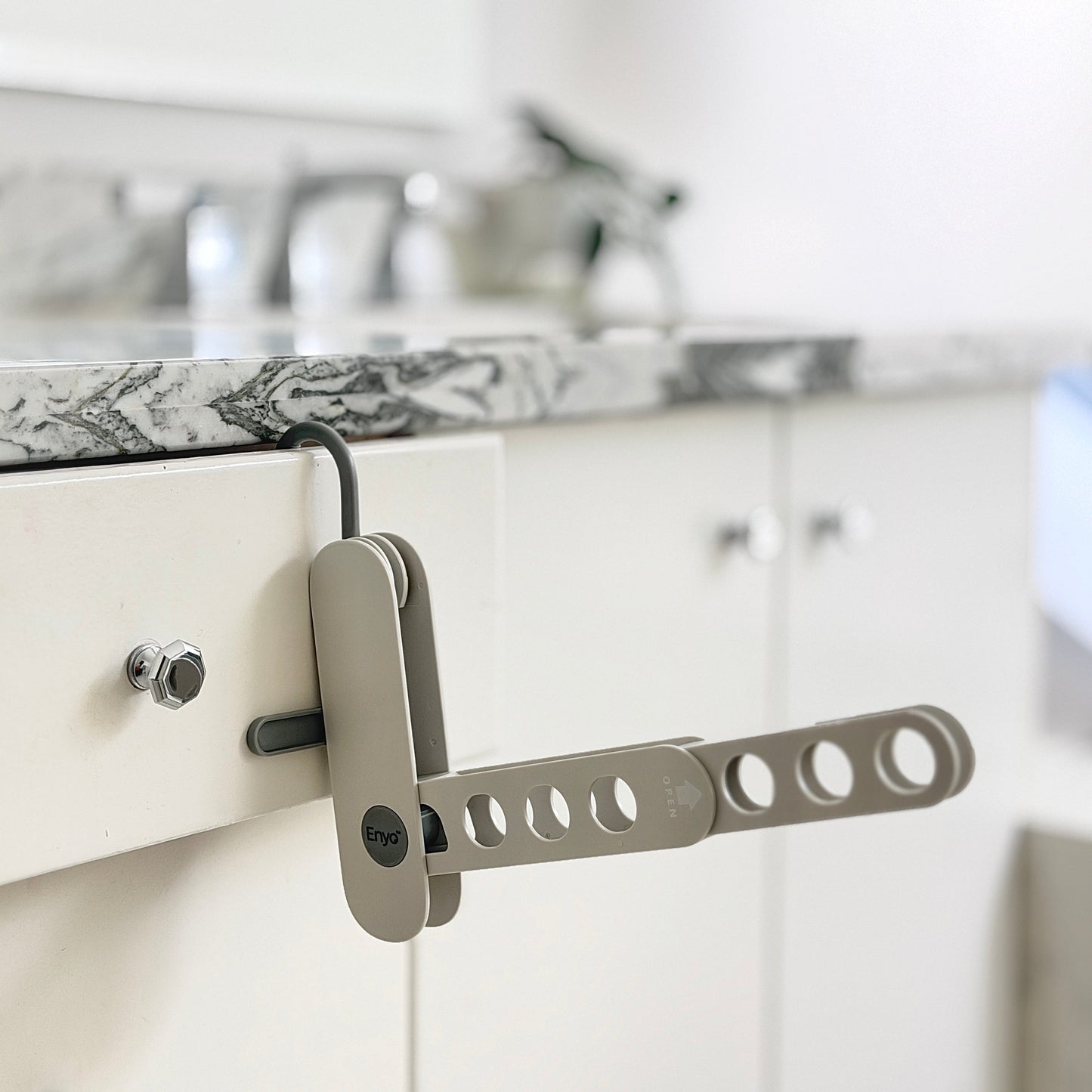 grey compact foldable hanger rack on a drawer in a washroom