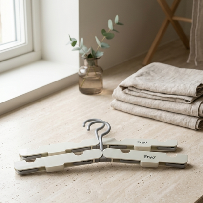 Foldable hanger on a kitchen counter with folded towels and a vase in the background