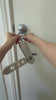 video of hands hooking a foldable hanger rack to a silver door knob